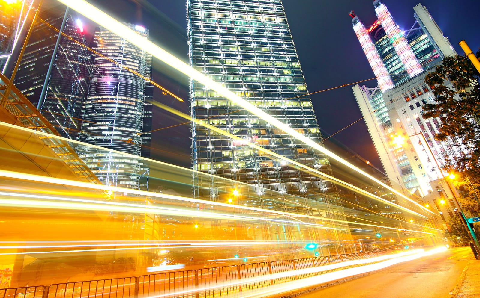 Lichtspuren des nächtlichen Verkehrs zwischen beleuchteten Hochhäusern